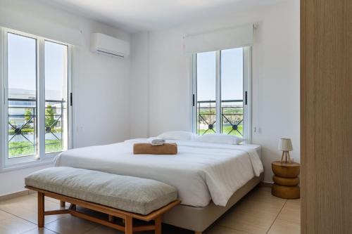 a white bedroom with a large bed and windows at 2BR Apartment with Amazing View and Pool in Kiti in Kiti