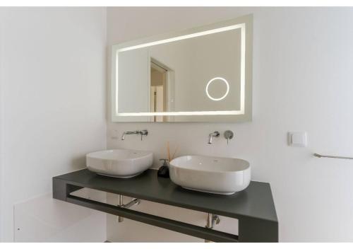 a bathroom with two sinks and a mirror at The pool house in Ponta de Sol in Funchal