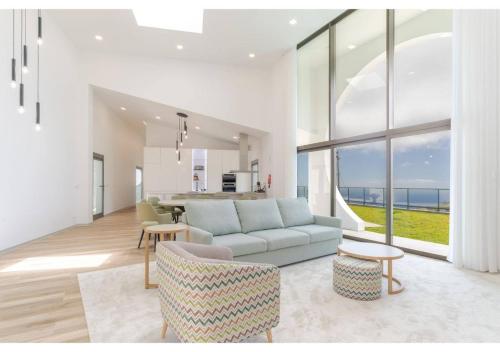 a living room with a couch and a table at The pool house in Ponta de Sol in Funchal