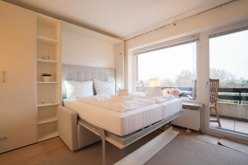 a bedroom with a large bed and a large window at Deichblick in List