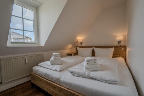 a bedroom with a bed with towels on it at Lister Tor 13 in List