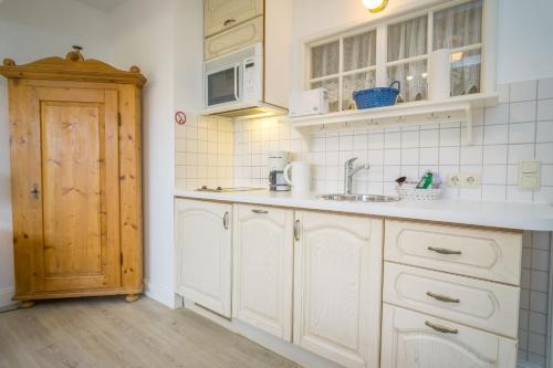a kitchen with white cabinets and a sink at Am Austernstrand in List