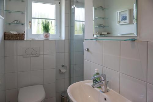 a white bathroom with a sink and a mirror at Iikhoarn in List
