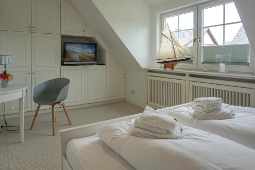 a room with two beds and a tv and a chair at Iikhoarn in List