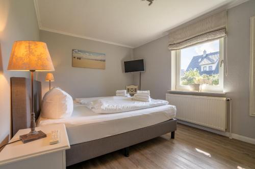 a bedroom with a large bed and a window at Lister Reede Garten in List