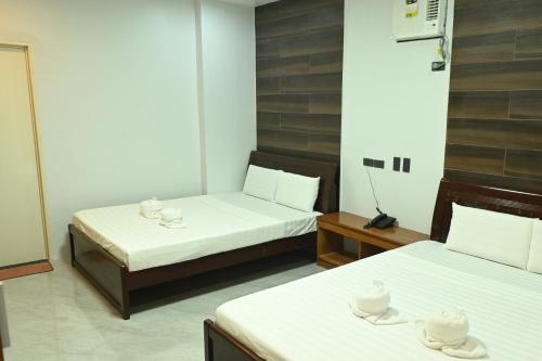 a room with two beds with hats on top of them at Lolita Heights Hotel in Tacloban