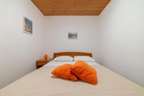 a bedroom with a bed with an orange towel on it at Nikola apartment in Božava