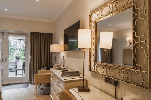 a hotel room with a vanity and a large mirror at Cragwood Country House Hotel in Windermere