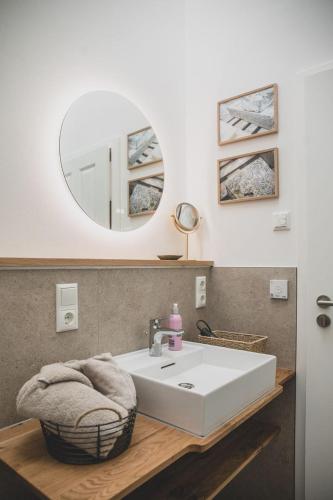 a bathroom with a white sink and a mirror at Gulfhof Wangermeer 8 Maila in Hohenkirchen