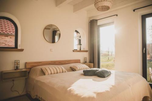 a bedroom with a large bed and a window at Gulfhof Wangermeer 8 Maila in Hohenkirchen
