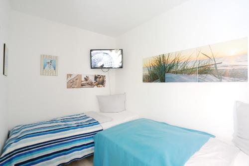 a bedroom with a bed and three pictures on the wall at Strandresidenz Timmendorfer Strand Seglernest in Timmendorfer Strand