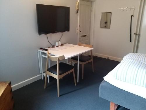 a room with a desk with a television and a bed at B&B SPS Downtown Copenhagen in Copenhagen