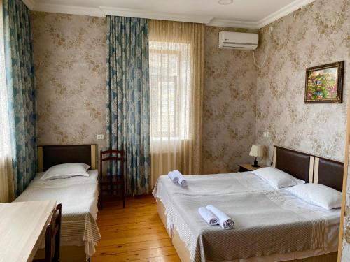 a bedroom with two beds and a window at HOTEL JULIA Akhaltsikhe in Akhaltsikhe