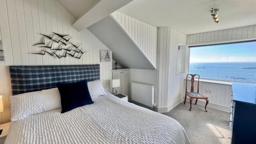 a bedroom with a large bed with a large window at HEADLANDS-2 BED-SEA VIEW APARTMENT-TREARDDUR BAY in Trearddur