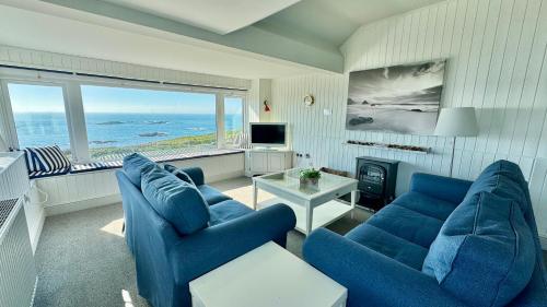 a living room with two blue couches and a television at HEADLANDS-2 BED-SEA VIEW APARTMENT-TREARDDUR BAY in Trearddur