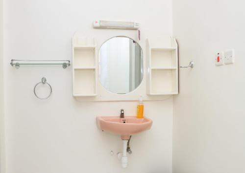 a bathroom with a pink sink and a mirror at Zaya Luxe Home in Naivasha