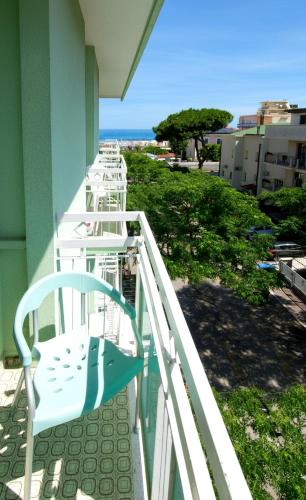 a white chair sitting on the balcony of a building at Hotel Ferrara in Cattolica