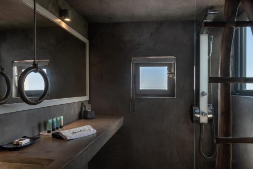 a bathroom with a sink and a mirror at West East Suites in Imerovigli