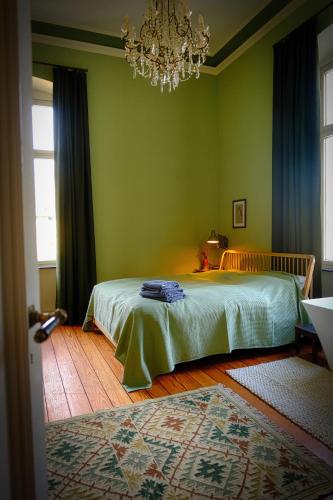 a green bedroom with a bed and a chandelier at DieMosel Minimal in Traben-Trarbach