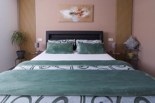 a bedroom with a large bed with green sheets and pillows at Ferienwohnung Nachtweide in Wadgassen