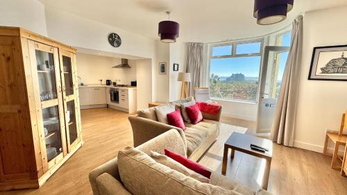 a living room with a couch and a table at 24 CLIFF APARTMENT-3 BED-GROUND FLOOR-SEA VIEWS in Trearddur