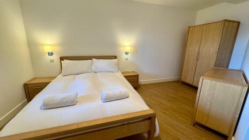 a bedroom with a large bed with two pillows on it at 24 CLIFF APARTMENT-3 BED-GROUND FLOOR-SEA VIEWS in Trearddur