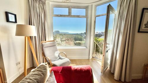a living room with a couch and a large window at 24 CLIFF APARTMENT-3 BED-GROUND FLOOR-SEA VIEWS in Trearddur