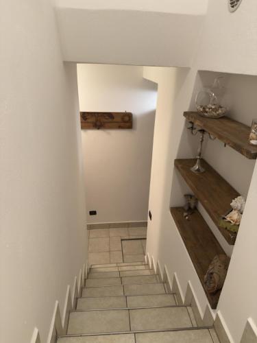 a staircase in a house with white walls and wooden shelves at House A73 in Lezzeno