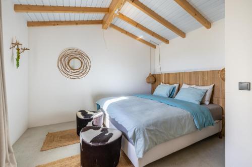 a bedroom with a bed with a wooden headboard at Casinha Revira Volta in Nesperal