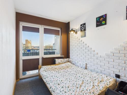 a bedroom with a bed and a large window at Mieszkanie na Alei in Głogów