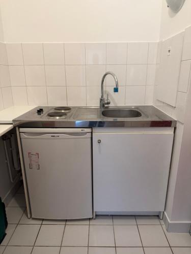 a small kitchen with a sink and a dishwasher at appartement cosy Paris 17eme in Paris