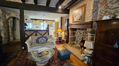 a living room with a couch and a brick wall at Maison de ville duplex TULLE in Tulle