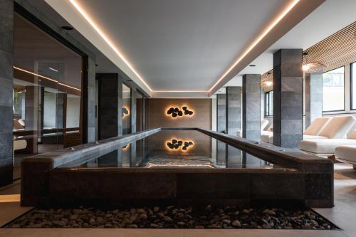 a large lobby with a fireplace in the middle at Marins Suites - Adults Only Hotel in Cala Millor