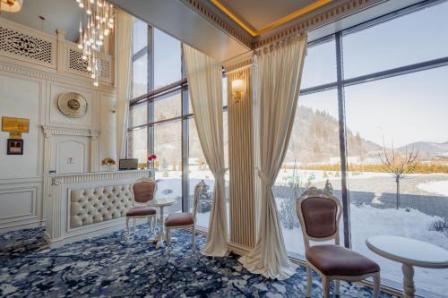 a room with a table and chairs and a large window at Grădina Mariajelor Hotel in Câmpulung Moldovenesc