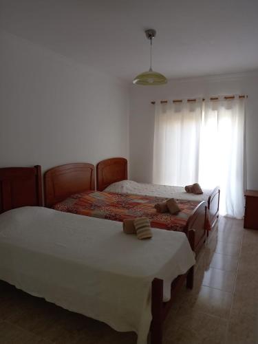 a bedroom with two beds and a window at Vilamoura Seaside Serenity T3 AP - Pool, BBQ, 3min Walk to Beach in Quarteira