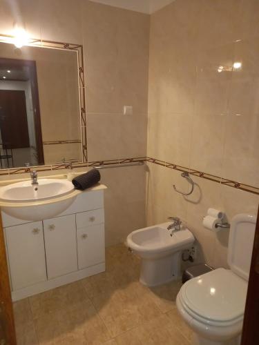 a bathroom with a sink and a toilet and a mirror at Vilamoura Seaside Serenity T3 AP - Pool, BBQ, 3min Walk to Beach in Quarteira