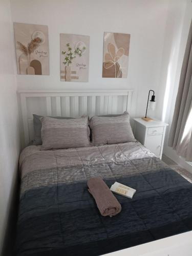 a bed with a blanket and a book on it at Casa Joseph in Aga