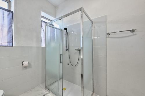 a shower with a glass door in a bathroom at Cesare Room in Apartment in Marghera