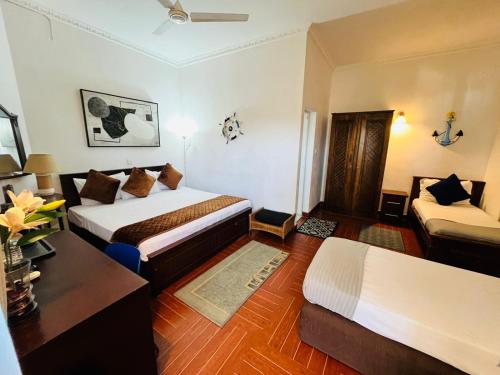 a hotel room with two beds and a table at The Ocean Pearl Hotel Negombo in Negombo