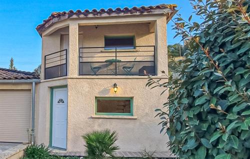 a house with a balcony and a tree at Maison Avec Piscine in Salavas