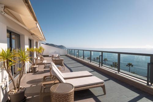 a balcony with chairs and a view of the ocean at Marins Suites - Adults Only Hotel in Cala Millor