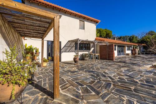 a stone patio in front of a house at Casinha Revira Volta in Nesperal