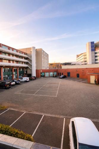 a parking lot with a tennis court in front of a building at Casaejon in Lelystad