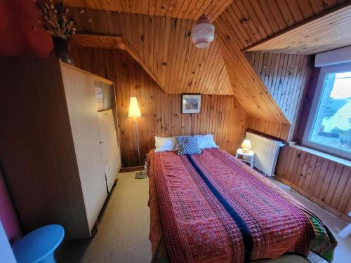 a bedroom with a large bed in a wooden room at La bien-aîmée in Ploubazlanec