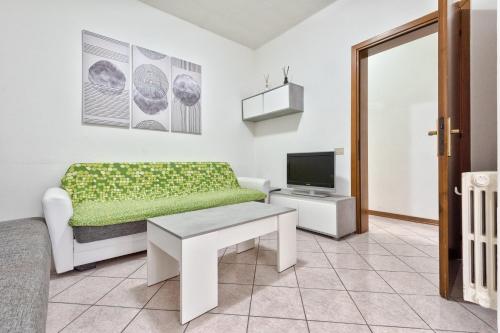 a living room with a couch and a tv at Marila 5, a due Passi dal Mare in Lido di Jesolo