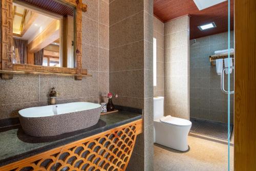 a bathroom with a sink and a toilet at Sunlit Snow Mountain Z Naxi Ethnic Style Courtyard in Lijiang