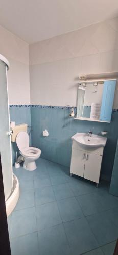 a blue and white bathroom with a toilet and a sink at Naparis Boutique in Eforie Sud