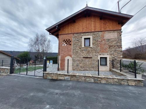 a building with a fence in front of it at Affittacamere il Gallo Panoramico - Alpine Trekking Stay in Donato