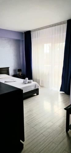 a bedroom with two beds and a large window at Naparis Boutique in Eforie Sud