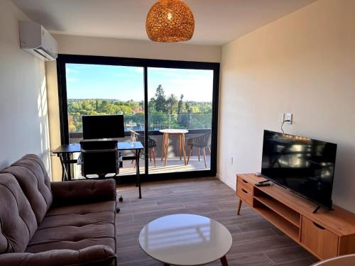 a living room with a couch and a tv and a table at Carmelo Postal in Carmelo